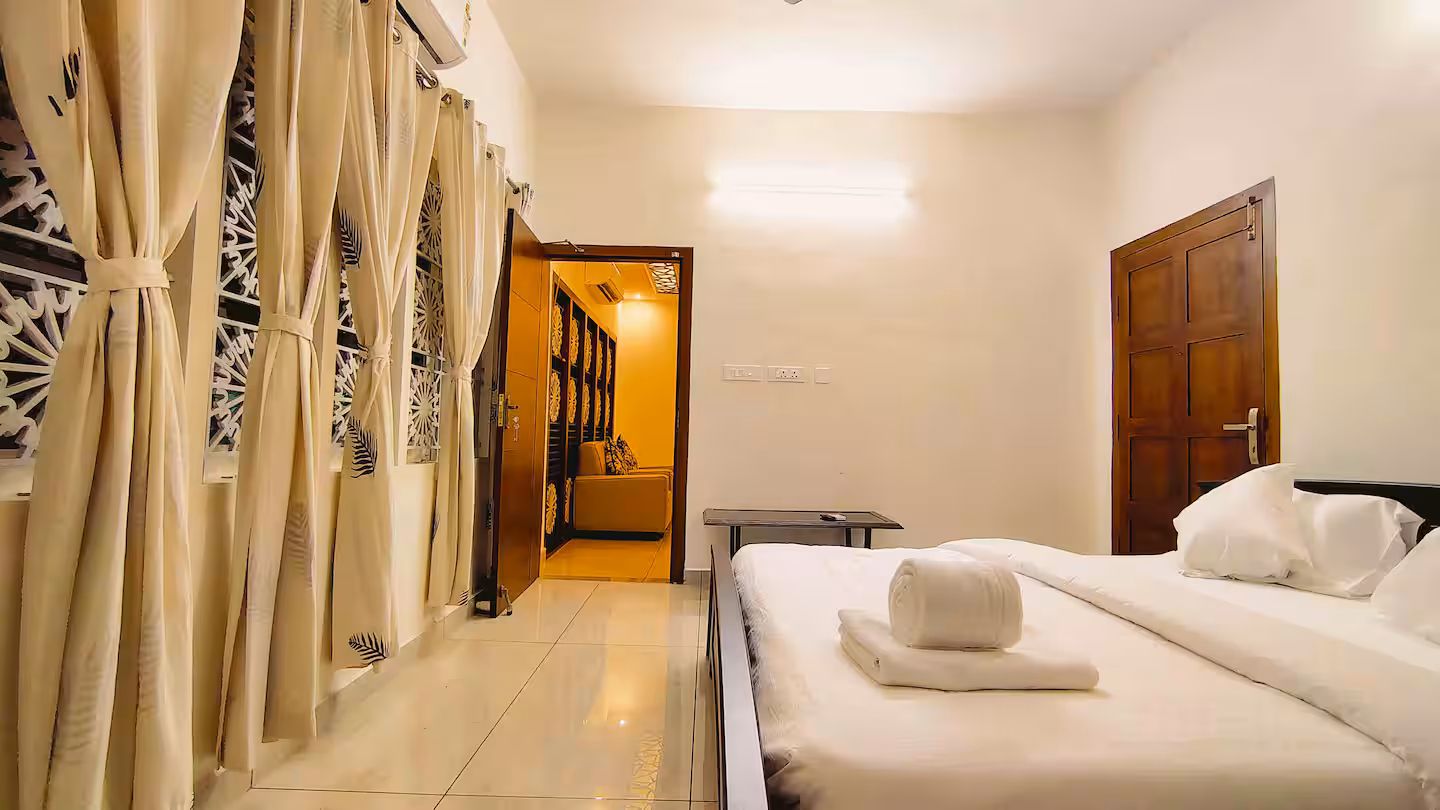Air-conditioned master bedroom with a luxury King bed at Riverside Retreat homestay Thiruvalla